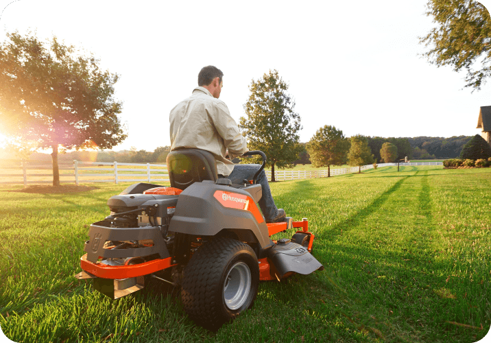 man on ride on mower in large property